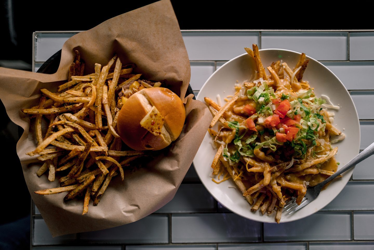 Overhead view of a burger, fries, and loaded fries prepared at 1129